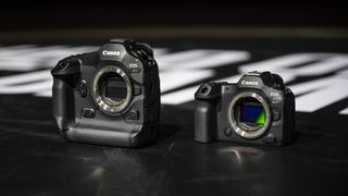 Canon EOS R1 mirrorless camera on the floor of a basketball court alongside the EOS R5 II, under the lights