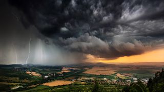 A severe thunderstorm shelf cloud races across the country side on a summer afternoon.