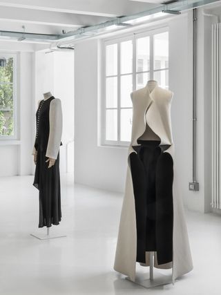 Installation image of Yohji Yamamoto exhibition at 10 Corso Como featuring sculptural black, white and red dresses