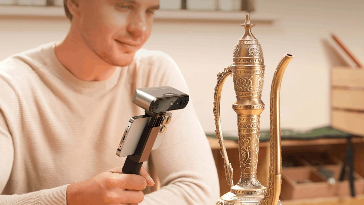 Smiling man scanning an ornament on his tablet with a 3D scanner