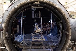 the inside of a large vacuum chamber is filled with wires and machinery