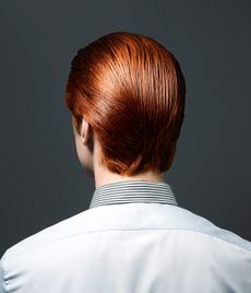 A man with red hair posing with his back to the camera