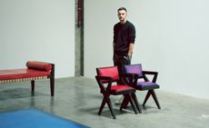 Male standing behind two chairs. 