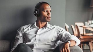 Man sitting wearing Harman Kardon Fly ANC.