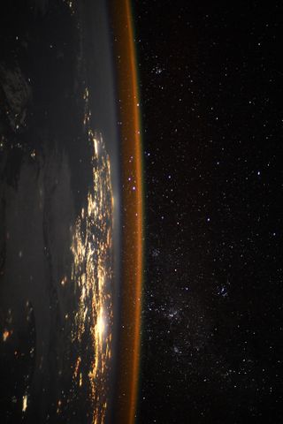 The sideways Earth glimmers in this photo taken from the International Space Station