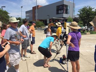 Spectators look at the sun through a telescope on the Southern Illinois University campus on Aug. 20, 2017, one day before the total solar eclipse.