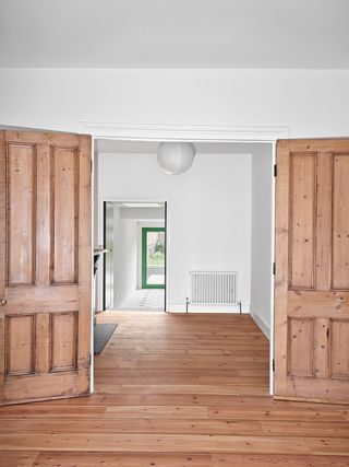 white walls and exposed timber floors and doors in London home