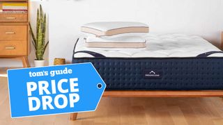 DreamCloud mattress with two pillows shown next to nightstand