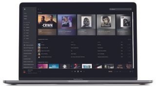 A laptop with a row of Tidal album art on screen.