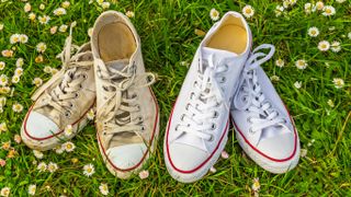 A dirty pair of canvas shoes next to a clean pair on the grass to explain how to clean white shoes