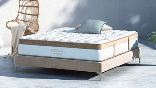 Saatva Classic mattress on a light brown fabric bed frame