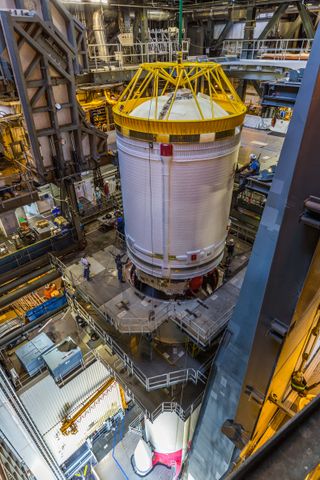 a rocket being assembled in a massive hangar