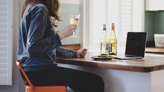 woman drinking wine at her laptop