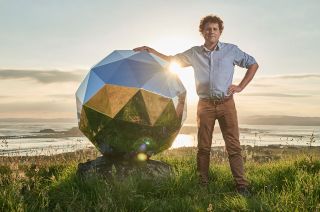 Rocket Lab founder and CEO Peter Beck stands with his creation,