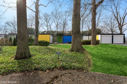 colourful views of michigan&#039;s modernist, single storey Frost House with large openings towards nature