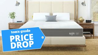 The Nolah Original mattress on a beige bedframe in a bright bedroom with a blue price drop sales badge overlaid on the bottom right corner