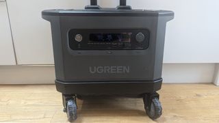 Ugreen PowerRoam 2200 power station on its wheeled stand on a wooden floor with a white cupboard backdrop