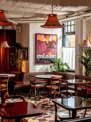 restaurant space and bar at cafe koko camden, tables and chairs with painting and plants surround