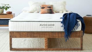 Avocado mattress sale, deals and promo codes: a navy throw is draped over the corner of an Avocado organic mattress