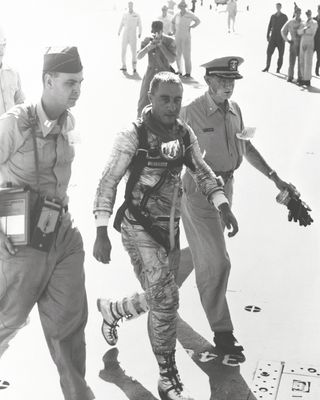 The Mercury pilot, flanked by military medical officers, is on the U.S.S. Randolph after his 1961 mission.