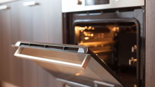 An oven with the door opened and interior light switched on