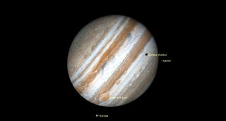 Jupiter hangs giant on its side with some moons.