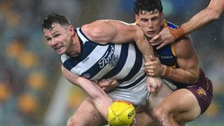 Patrick Dangerfield (L), wearing the Cats navy blue and white striped vest, of the Cats (L) is tackled by Jarrod Berry of the Lions in the Geelong vs Brisbane live stream.