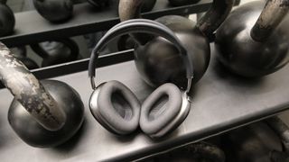 Apple AirPods Max at the gym surrounded by kettlebells