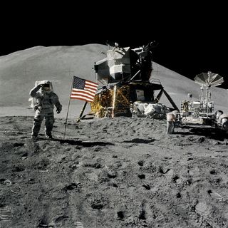 Astronaut James B. Irwin, lunar module pilot, during the Apollo 15 lunar surface extravehicular activity (EVA) on August 1, 1971, at the Hadley-Apennine landing site. The first Lunar Roving Vehicle (LRV) on the moon, stands to the right.