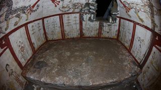 A wide angle shot of the tomb showing intricate paintings on the wall