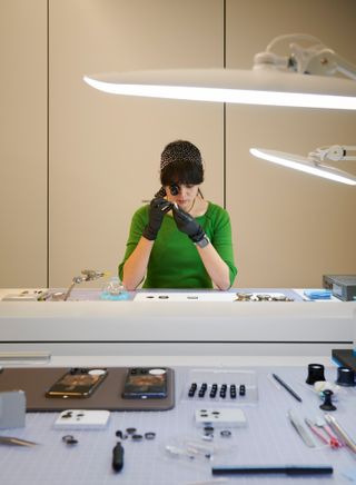 View of a model maker at Apple Park assembling a digital crown onto an Apple Watch Series 7