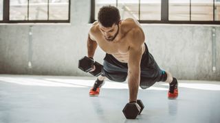 Man performing dumbbell renegade rows