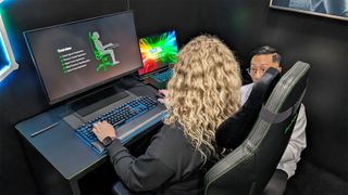 Rebecca Spear sitting in a Razer Iskur V2 and talking to Dr. Matthew Hwu.