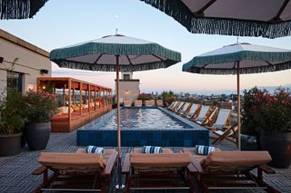 Hotel swimming pool, umbrellas over deck chairs