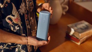 Sonos Roam 2 portable speaker held by a man wearing a Hawaiian shirt