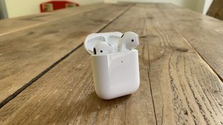 Apple AirPods 3 in their case on a wooden table
