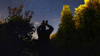 An amateur astronomer using binoculars to look at the stars