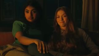 Avantika and Larsen Thompson&#039;s characters sit next to each other in a candlelit room in a scene from the movie Tarot.