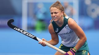 Ambrosia Malone, in her green and white Australia strip and hockey stick in hand, ahead of the Paris Olympics Games 2024.