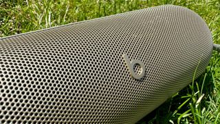 Beats Pill Bluetooth speaker on grass close-up on grille and Beats logo