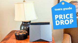 The TP-Link Archer GE800 on a table with a Tom's Guide Price Drop deals badge