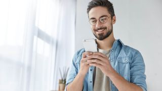 A man smiling at his phone