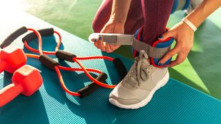 a photo of a woman putting some best ankle weights on