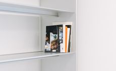 Metal shelves of International Library of Fashion Research with handful of magazines