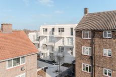 seen from the distance, among brick housing, the white volume of citizens house by archio in south london