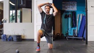 Man performing a half kneeling kettlebell halo in the gym