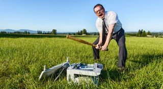 Man beating office printer with a bat in a field.