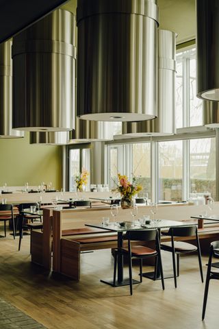 green dining room with cylindrical steel lighting