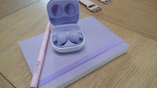 Purple Samsung Galaxy Buds 2 on a notebook