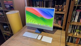 The 2023 M3 iMac on a wooden desk, showing the features of macOS Sonoma